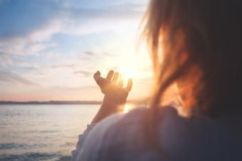 woman trying to grab the sun