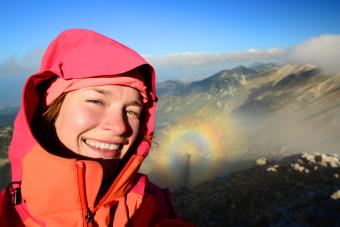 Selfie of a female hiker with broken spectre optical phenomenon shadow