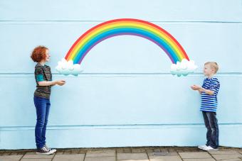 Boy and girl holding cartoon rainbow