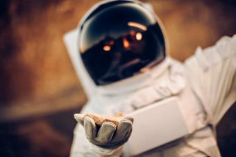 Astronaut holding rock-object from the moon