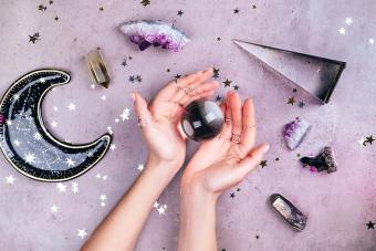 Hands holding crystal ball near esoteric set 