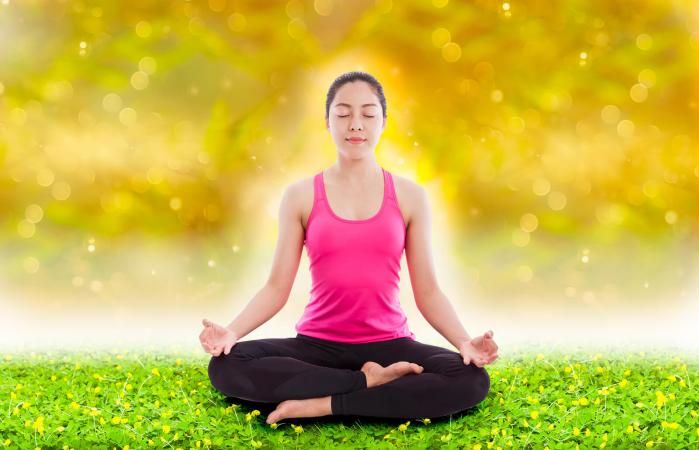 woman practicing yoga with aura over body