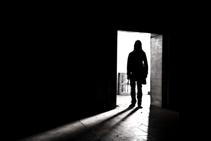 Man entering darkened room