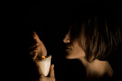 Woman in a dark room with a candle