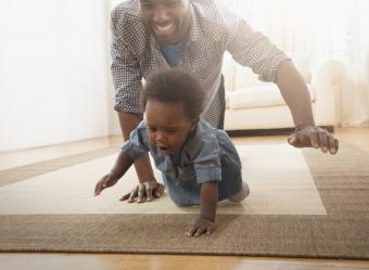 Dad crawling on floor with his baby daughter