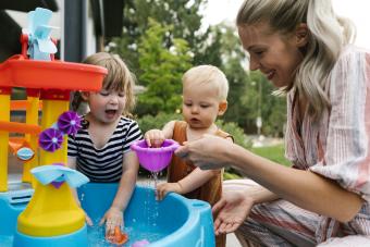 Mom playing with baby and daughter in water