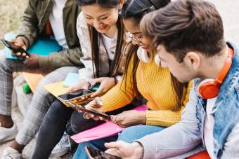 Teenage students having fun using mobile phone