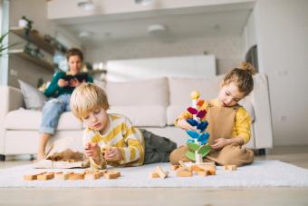 Small brother and sister playing with marble run at home