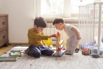 Sibling playing together with wooden toy