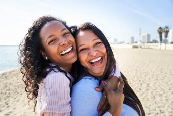 Mother and daughter taking selfie on beach