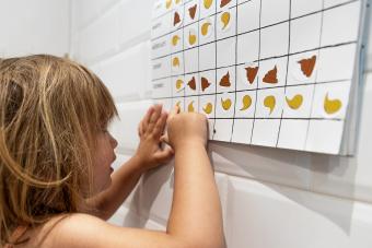  little girl looking and pointing at her pee and poop calendar