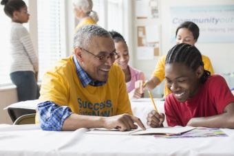 Volunteers tutoring students in classroom