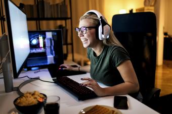 Young blonde girl playing a video game on her computer