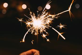 Hand holding a burning sparkler at a party 