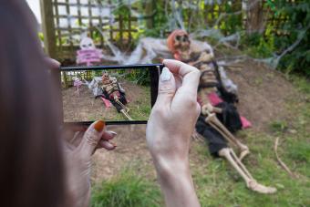 woman taking picture of skeleton yard decoration