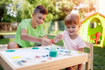 brother and sister painting outside in yard