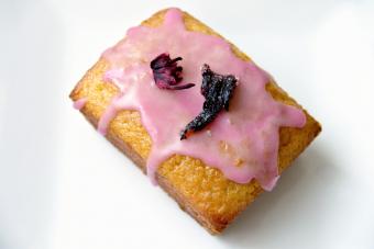 Olive oil cake with hibiscus-flavored icing and dried hibiscus flower garnish