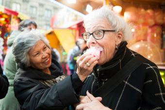 Active senior girlfriends enjoying cotton candy at the fair