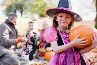 girl in Halloween witch costume with family