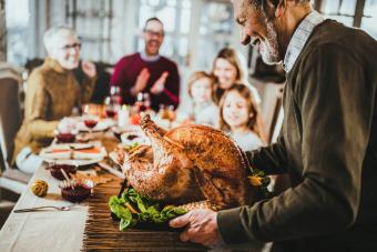 senior man bringing Thanksgiving turkey to the table