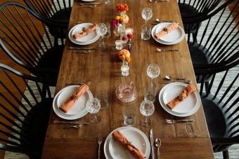 Plates with wineglasses arranged on dinner table in dining room