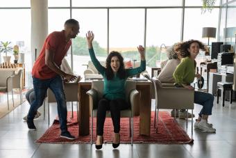 Cheerful friends playing musical chairs