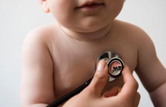 Doctor listening to chest of baby