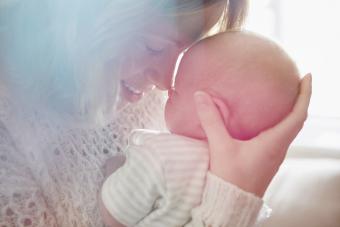 Mother hugging newborn baby