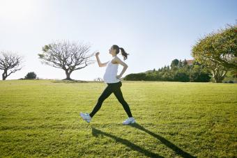 Pregnant woman exercising in field