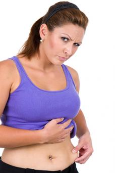 Woman pinching post-pregnancy skin