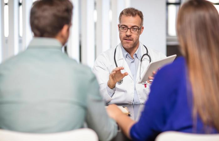Doctor talking to couple about male birth control methods