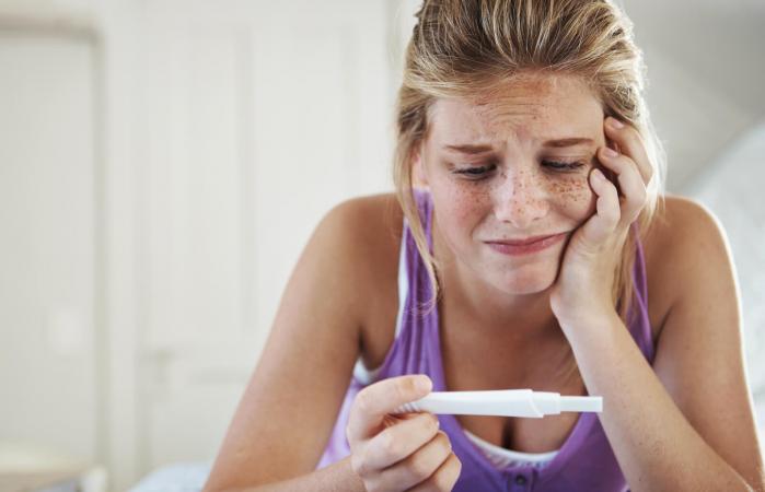 Teenage girl looking at pregnancy test