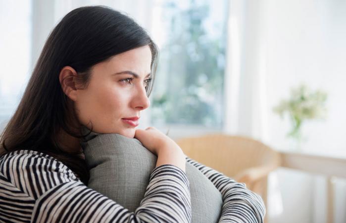 Pensive woman clutching pillow