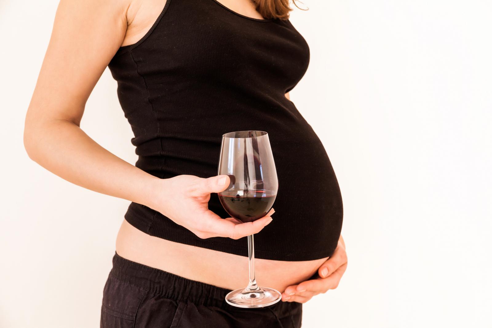Very pregnant woman with an empty wine glass