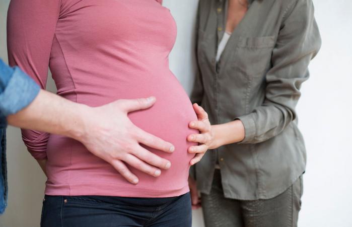 Hands on the belly of a pregnant woman
