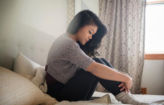 Sad woman sitting on bed