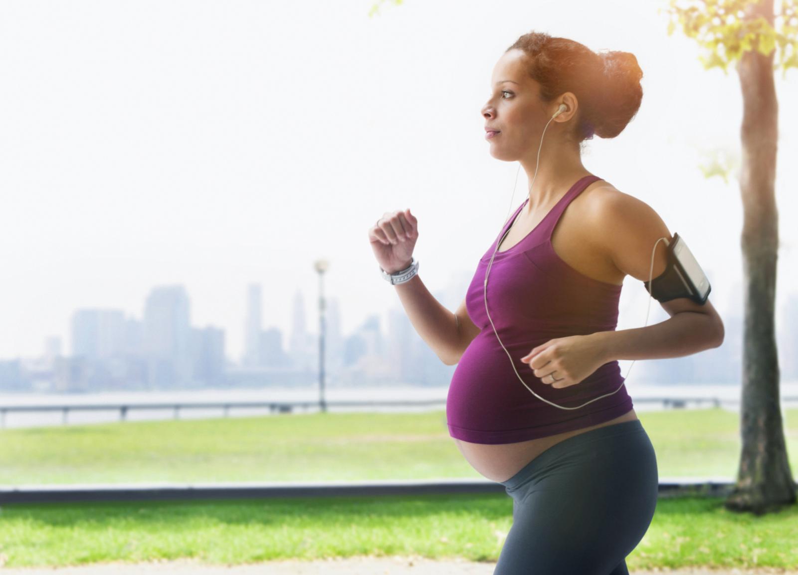 Pregnant woman power walking in park
