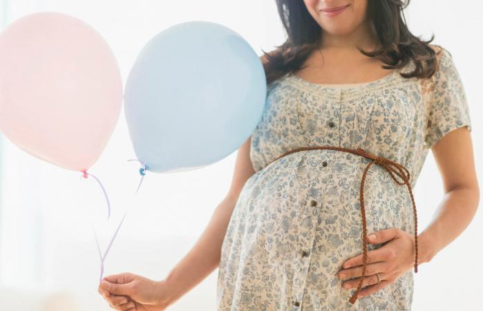 Pregnant woman carrying balloon