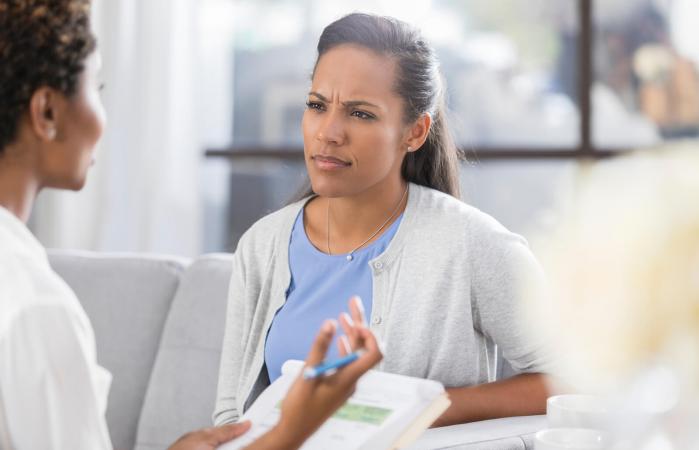 Confused woman listens to doctor