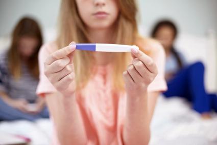 Teenagers looking at pregnancy test