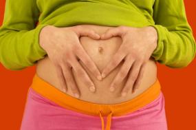 Pregnant woman making a heart over her belly