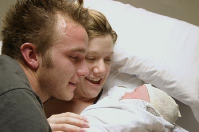 A couple enjoying their newborn baby