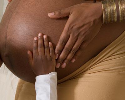 Child's hand on pregnant mom's belly