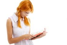Young woman reading a book about conception