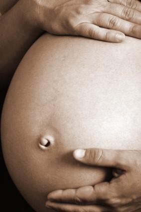 Older pregnant woman holding her belly
