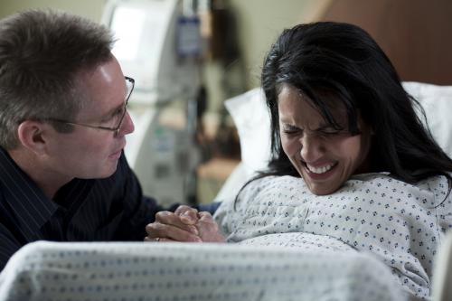 woman in labor pushing with partner coaching
