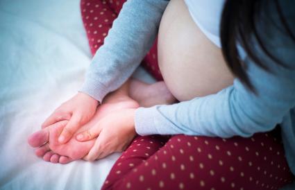 Pregnant woman rubbing foot