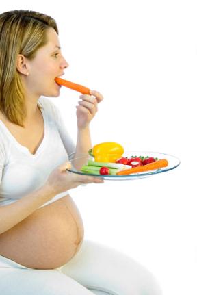 Pregnant woman eating fresh vegetables