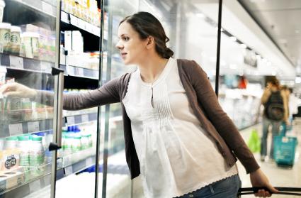 Pregnant woman in supermarket buying groceries
