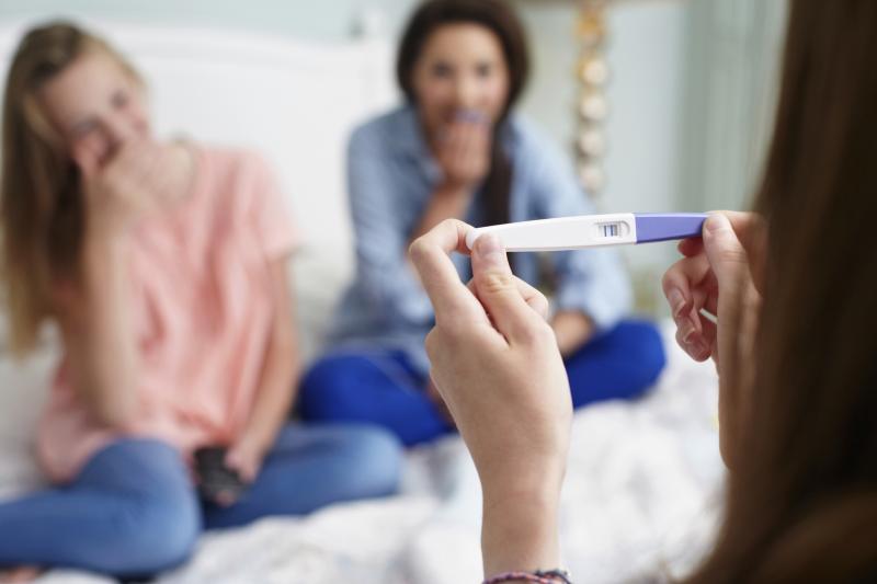 girls laughing at friend's pregnancy
